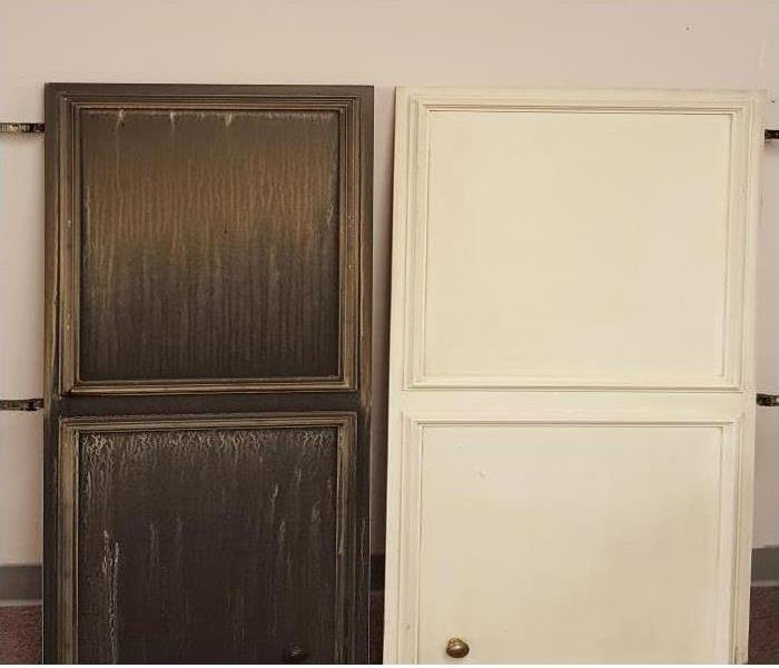 Two cabinets leaning against a wall that have suffered smoke damage
